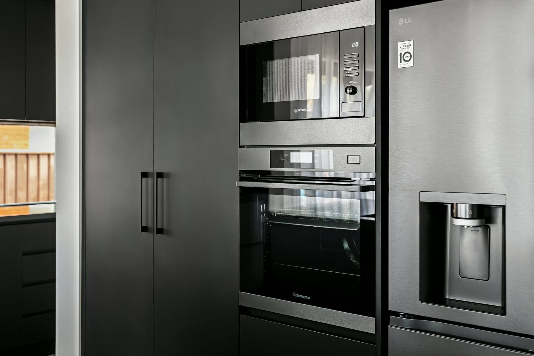 Dark handleless cabinetry and a warm timber benchtop